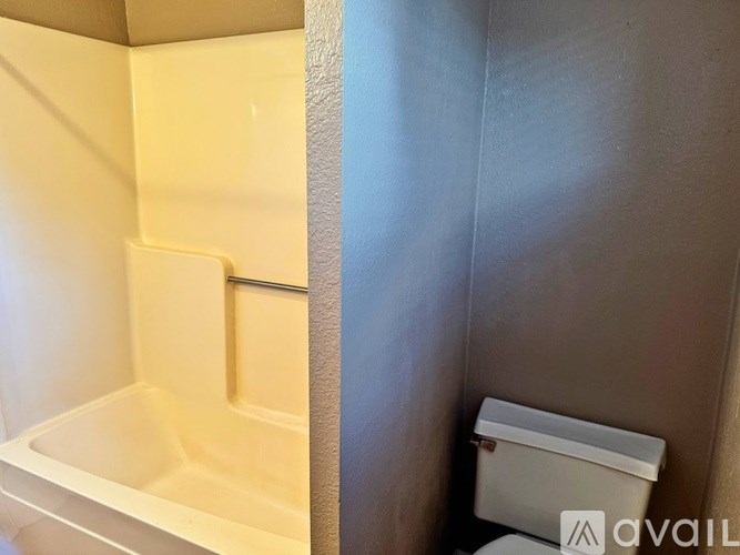 A white toilet is next to a bathtub in a bathroom.