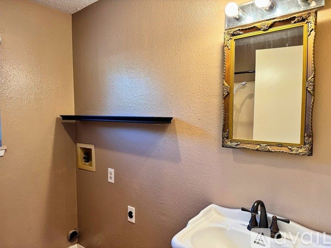 A bathroom with a sink, mirror, and light switch.