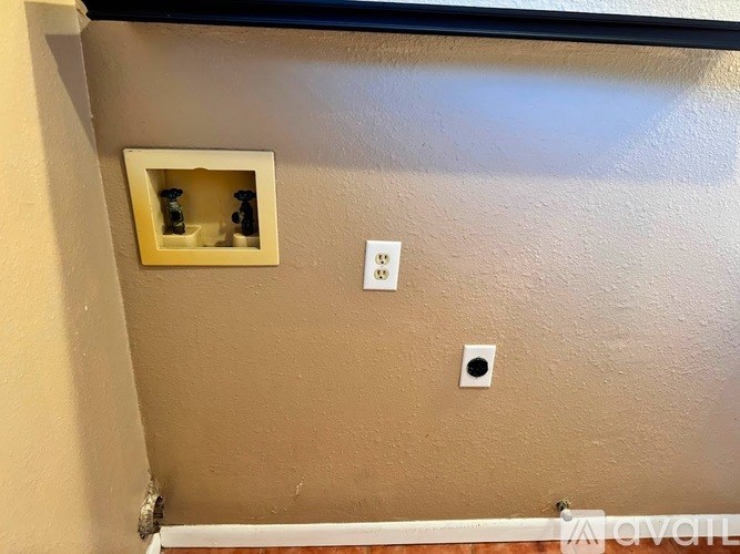 A wall with a socket and a switch.