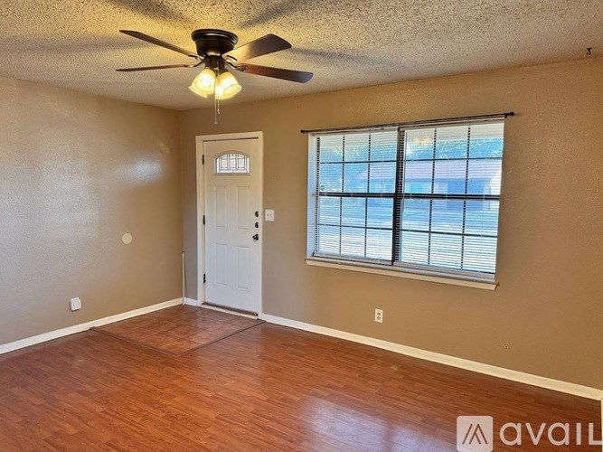 A room with a ceiling fan and a window with blinds.