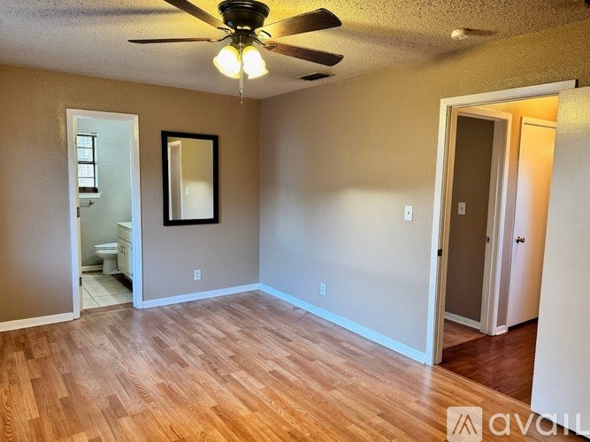 A room with wooden floors and a ceiling fan.