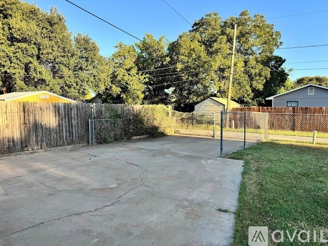 A backyard with a fence and a tree.