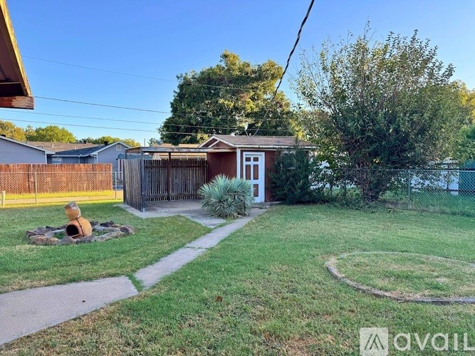 A backyard with a fire pit and a fence.