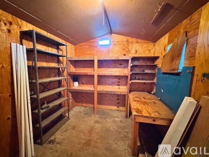 A room with wooden walls and shelves filled with boxes and other items.