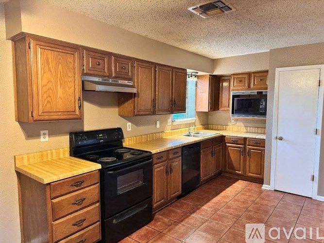 A kitchen with wooden cabinets and a black stove top oven.