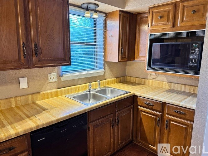 A kitchen with wooden cabinets and a sink.