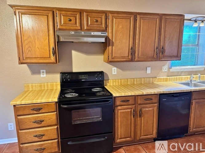 A kitchen with wooden cabinets and a black stove top oven.