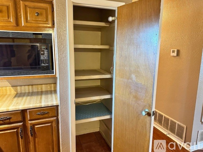 A kitchen with an open pantry door.