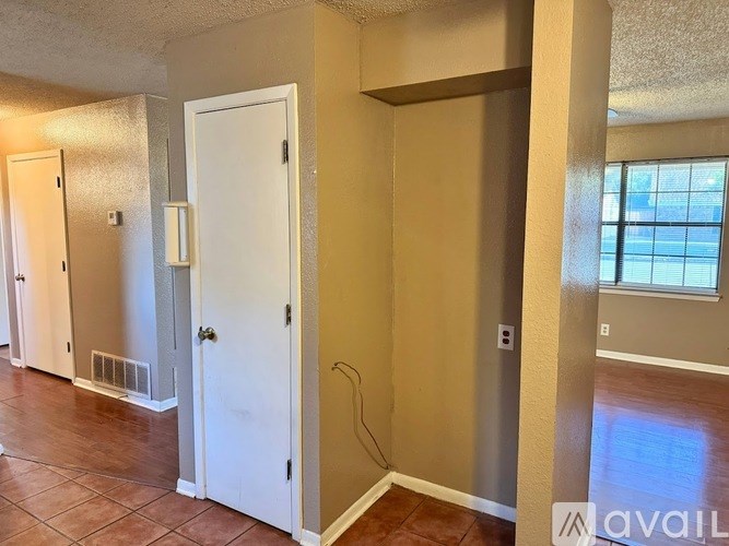 A room with a white door and a window on the right side.