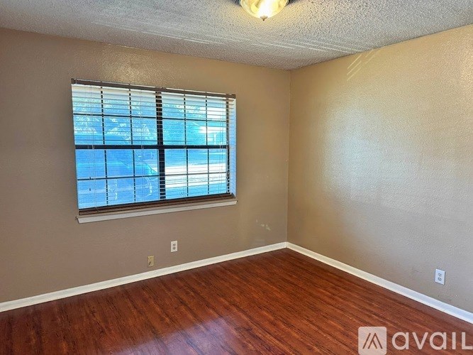 A room with a window and wooden flooring is available for rent.