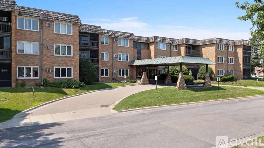 A large brick apartment complex with a green roofed entrance.