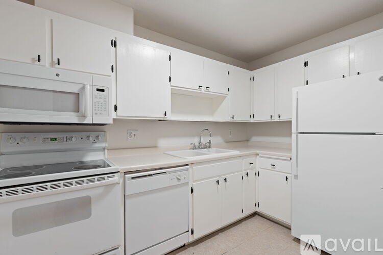 A kitchen with white appliances and cabinets.