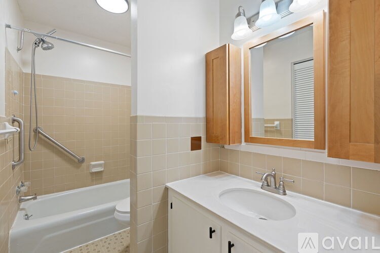 A bathroom with a white sink and a white bathtub with a shower head.