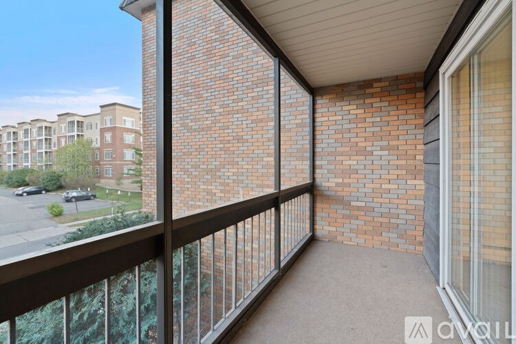 A balcony with a brick wall and glass doors.