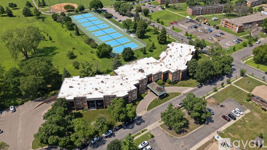An aerial view of a building with a swimming pool in front of it.