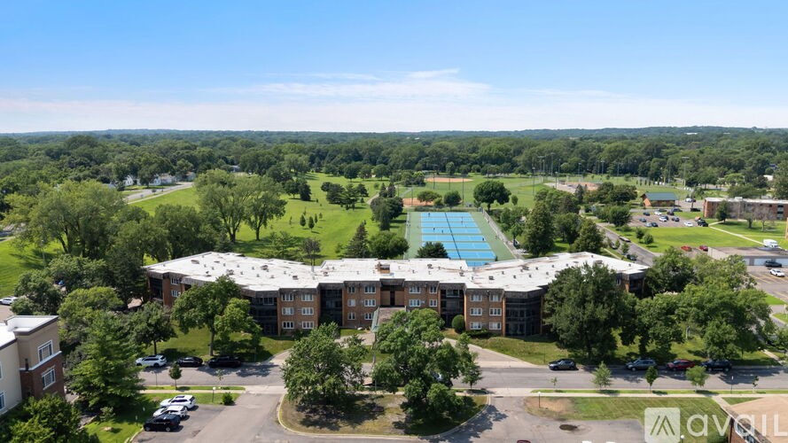 An aerial view of a large building with a swimming pool in front of it.