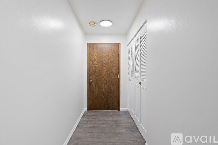 A hallway with a wooden door and white walls.