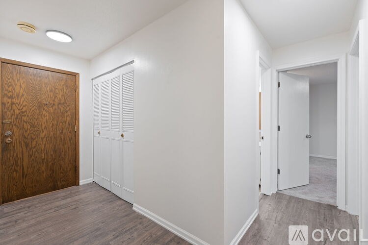 A room with a wooden door and white walls.
