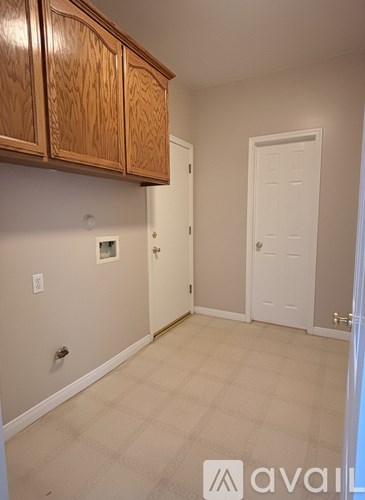 A room with wooden cabinets and a white door.
