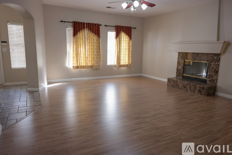 A spacious living room with a fireplace and hardwood floors.