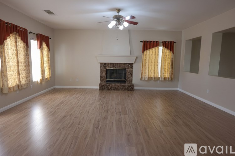A living room with a fireplace and a fan on the ceiling.