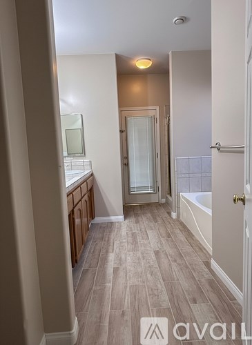 A bathroom with a tub, sink, and shower.