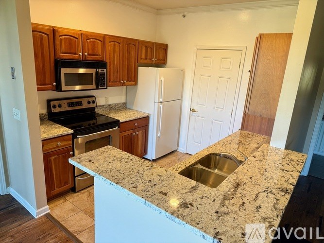 A kitchen with granite countertops and a white refrigerator.