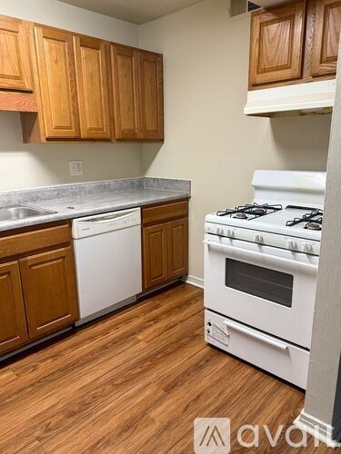 A kitchen with wooden cabinets and a white stove.