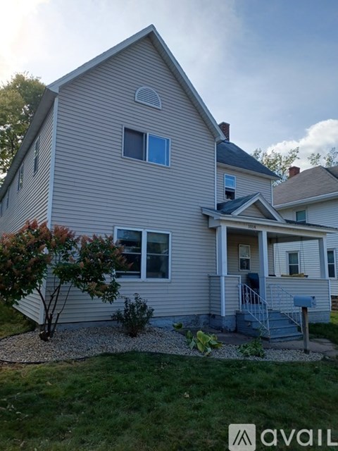 A house with a grey siding and a small front porch.