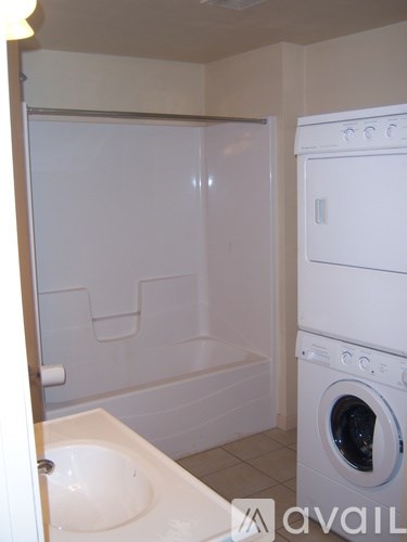 A white washing machine and dryer in a small bathroom.