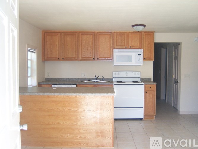 A kitchen with wooden cabinets and white appliances.