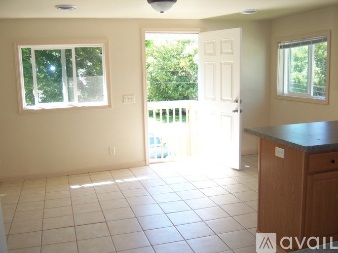 A room with a tiled floor and a sliding glass door leading to a balcony.