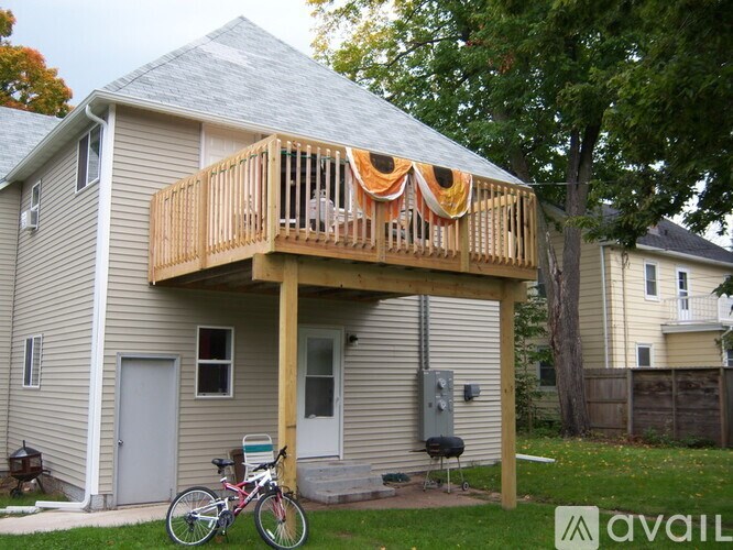 A house with a deck and a bicycle parked in front.