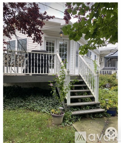 A patio with a table and chairs under an orange umbrella.