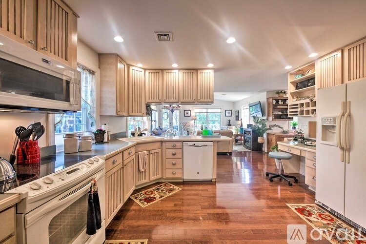 A kitchen with wooden cabinets and a white stove top oven.