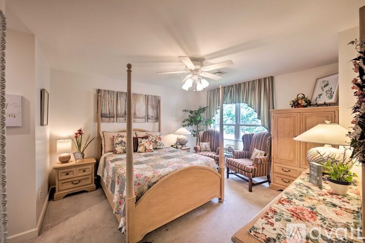 A bedroom with a large bed and a ceiling fan.