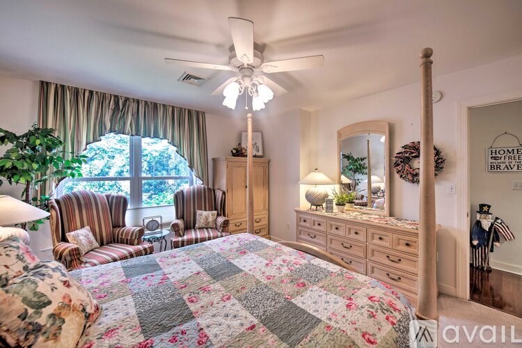 A bedroom with a large bed and a ceiling fan.