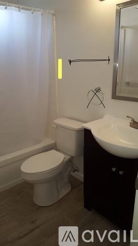 A bathroom with a toilet, sink, and shower.