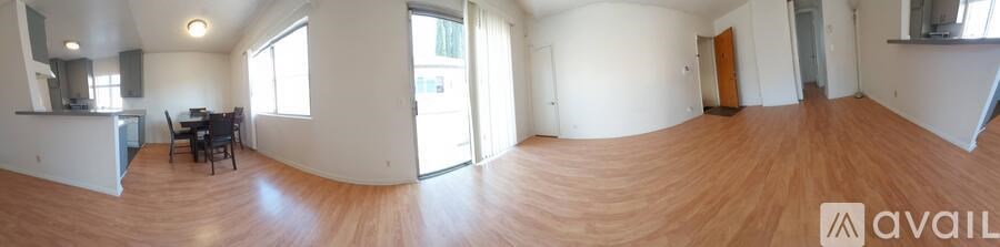 A large empty room with wooden floors and white walls.