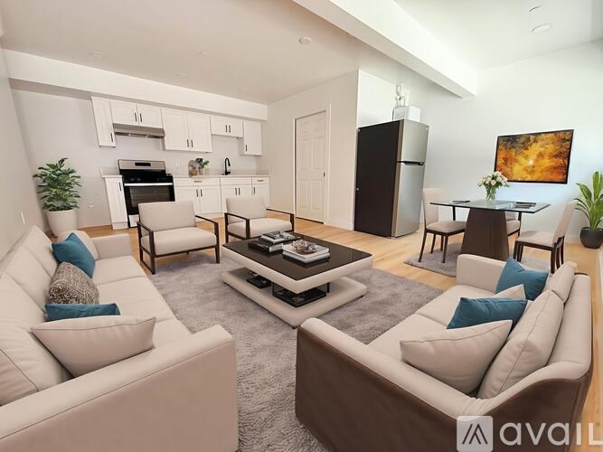 A modern living room with a white sofa, a brown sofa, a coffee table, and a kitchen area in the background.