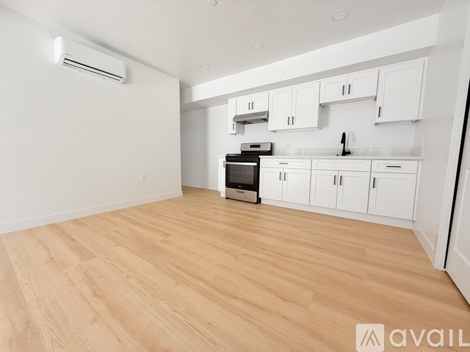 A kitchen with white cabinets and a wooden floor.