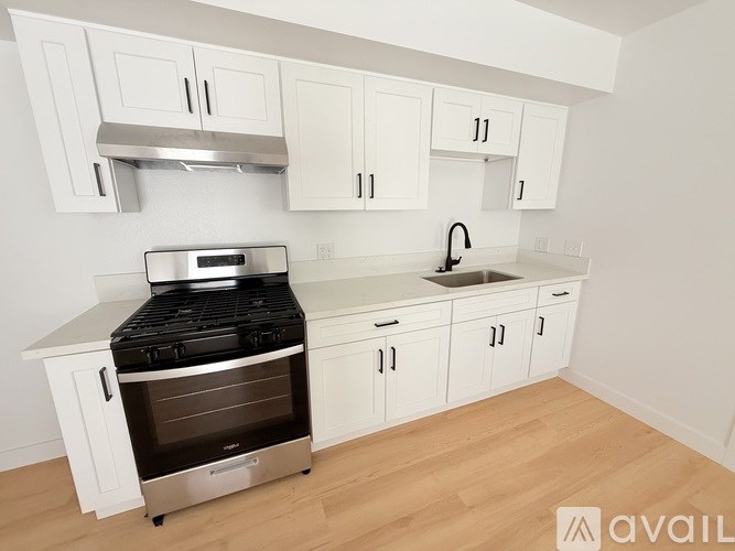 A kitchen with white cabinets and a stove top oven.