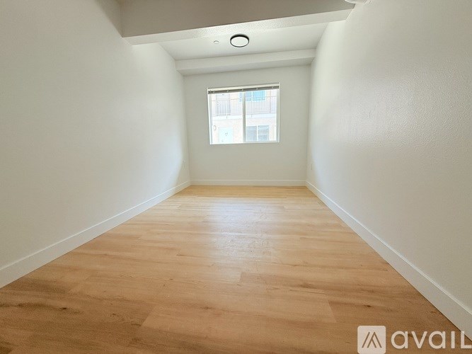 A room with wooden flooring and a window.