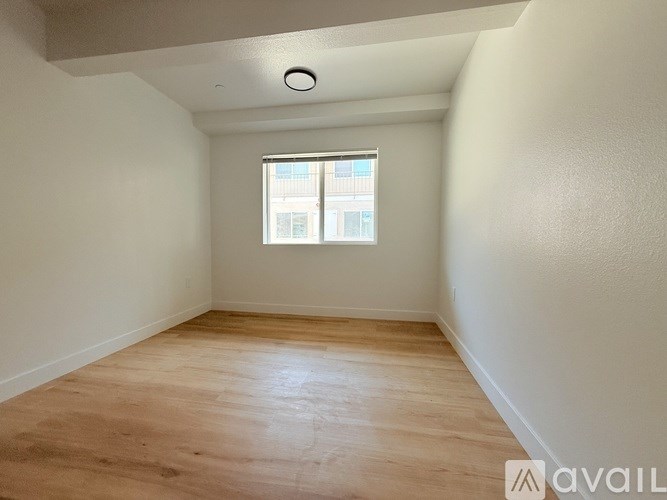 A room with wooden flooring and a window.