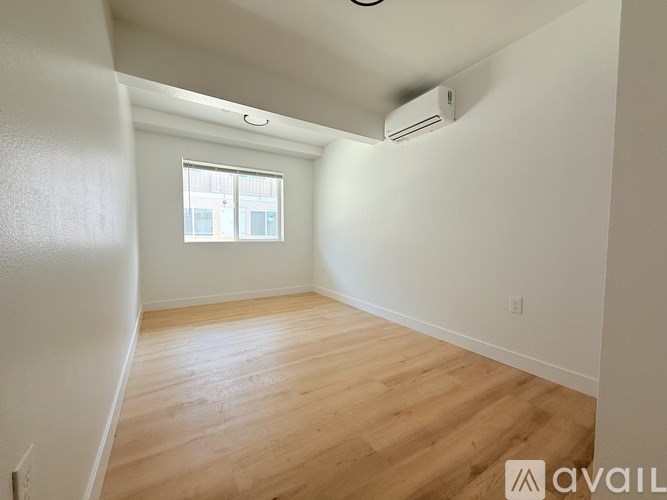 A room with wooden flooring and a window.