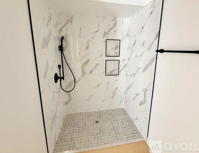 A bathroom with a marble wall and a tiled floor.