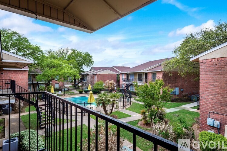 A view from a balcony overlooking a pool and apartment buildings.