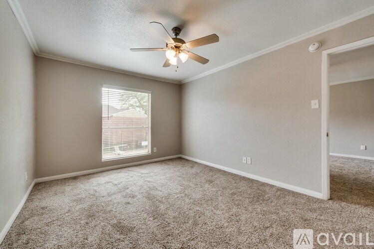 A room with a ceiling fan and carpeted floor.