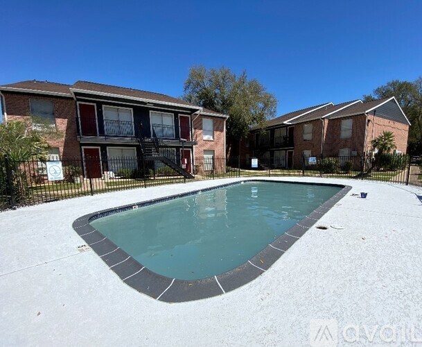 A swimming pool in front of a brick building.