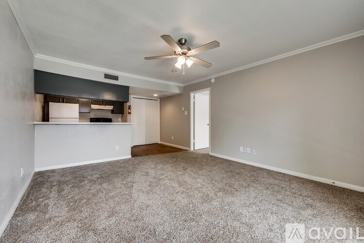 A spacious room with a ceiling fan and carpeted floor.
